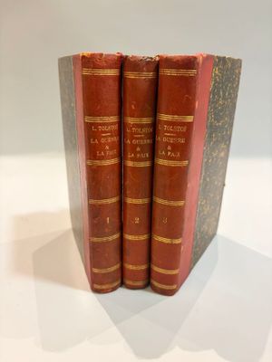 three red books are stacked on top of each other on a table