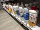 many bottles of water sitting on a shelf in a store
