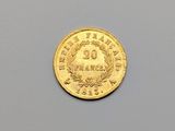 gros plan d'une pièce d'or sur une surface grise