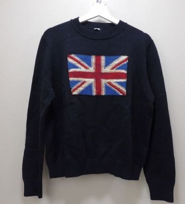 Le pull est orné d'un drapeau britannique et est suspendu à un cintre.