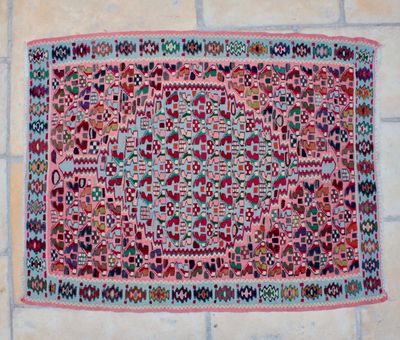 a pink rug on a tiled floor with a white tile floor