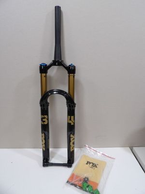 a black and gold bike fork with a bag on the table