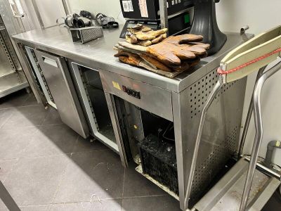 stainless steel counter with oven and ovening equipment in a commercial kitchen