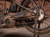 an old motorcycle parked in front of a brick wall