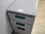 a filing cabinet with two drawers next to a wall