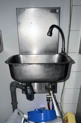 un évier équipé d'un robinet, avec une poubelle en dessous