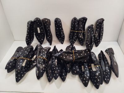 plusieurs paires de chaussures à pois noirs et blancs posées sur une surface blanche