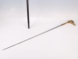a close up of a sword and a stick on a white surface