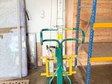 un diable vert avec une poignée jaune dans un garage