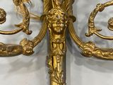 an image of a gold candle holder on a white wall