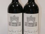 two bottles of wine sitting on top of a table next to each other