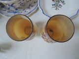 two cups of tea sitting on a table next to a plate
