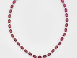un collier rose avec un pendentif en forme de larme sur une chaîne en argent