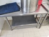 une grande casserole en métal posée sur une table dans une cuisine