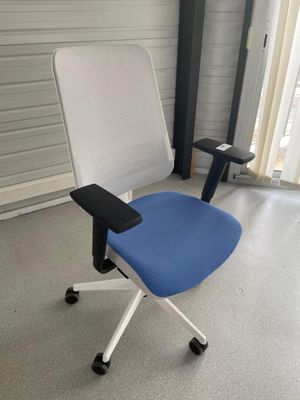 une chaise de bureau bleue et blanche dans un coin de la pièce