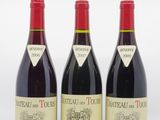 trois bouteilles de vin rouge posées l'une à côté de l'autre sur une surface blanche