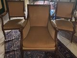 three chairs in a living room with a rug on the floor