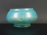 un vase bleu sur lequel figurent des inscriptions, posé sur une table