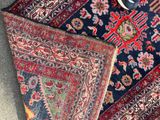 a pair of scissors sitting on top of a pile of rugs