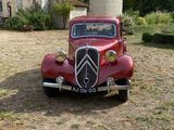 an old red car parked in front of a castle