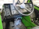 a green vehicle with a steering wheel and a dashboard