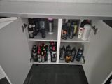 a white cabinet with a lot of bottles and bottles on it