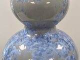a blue and white vase sitting on a white table