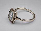 a close up of a silver ring with a blue topaz stone
