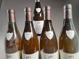 four bottles of wine are lined up on a table