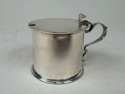 a silver cup with a handle on a white table