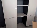 une photo d'une pièce avec un bureau d'ordinateur et des armoires