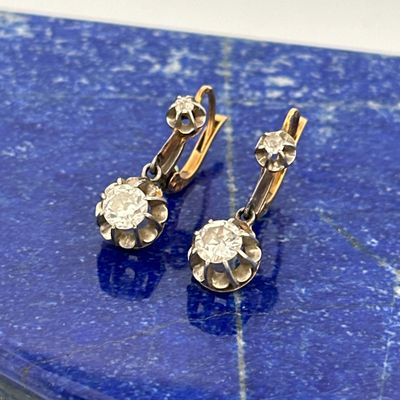 pair of diamond earrings on a blue marble surface
