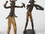 three figurines of a man and a woman with horns on their heads