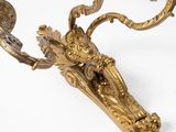 a gold plated wall sconce with a bird on it