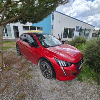 a red car parked in front of a building next to a tree
