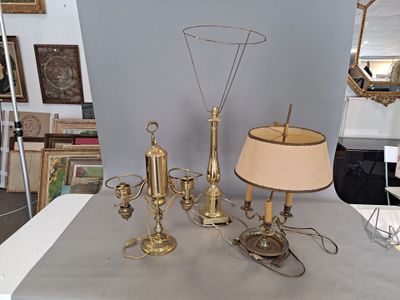 a table with a lamp, a lamp shade, and a mirror on it
