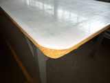 a white table with a yellow edge in a room