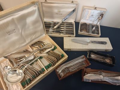 a box of silverware on a table with other silverware in it