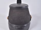 a black pot with a lid sitting on a white surface