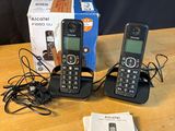 three cell phones are sitting on a table with a box on the table