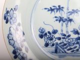 a blue and white plate with a picture of flowers on it