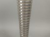 un vase en argent posé sur une table, sur fond blanc