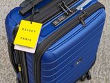a blue suitcase with a tag on it sitting on the floor