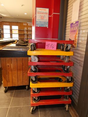a stack of red, yellow, and red carts in a store