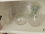 bottles and glasses on a shelf in a cabinet with a toothbrush
