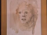 painting of a woman ' s face in a frame on a wall