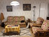 a living room with a couch, chair, table and lamp in it