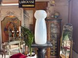 a white vase sitting on top of a table in a room