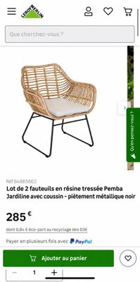 une photo d'une chaise en osier sur laquelle est posé un coussin blanc
