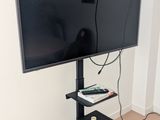 un téléviseur à écran plat posé sur un support dans le coin d'une pièce